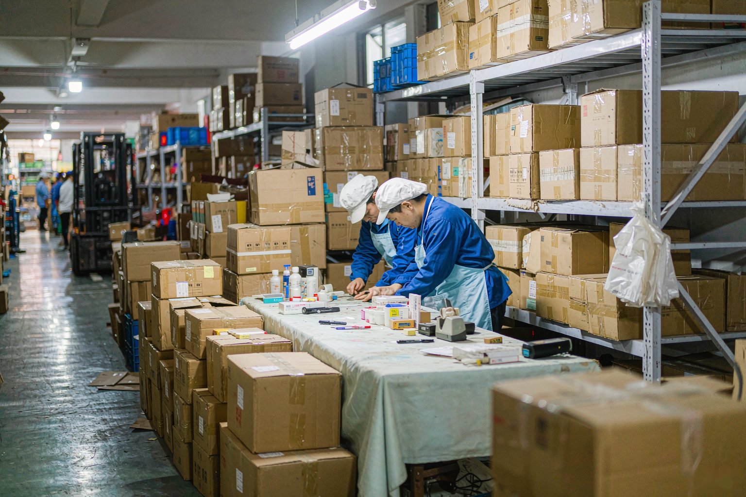 Workers checking cartons inside the Hong Sourcing warehouse in Foshan